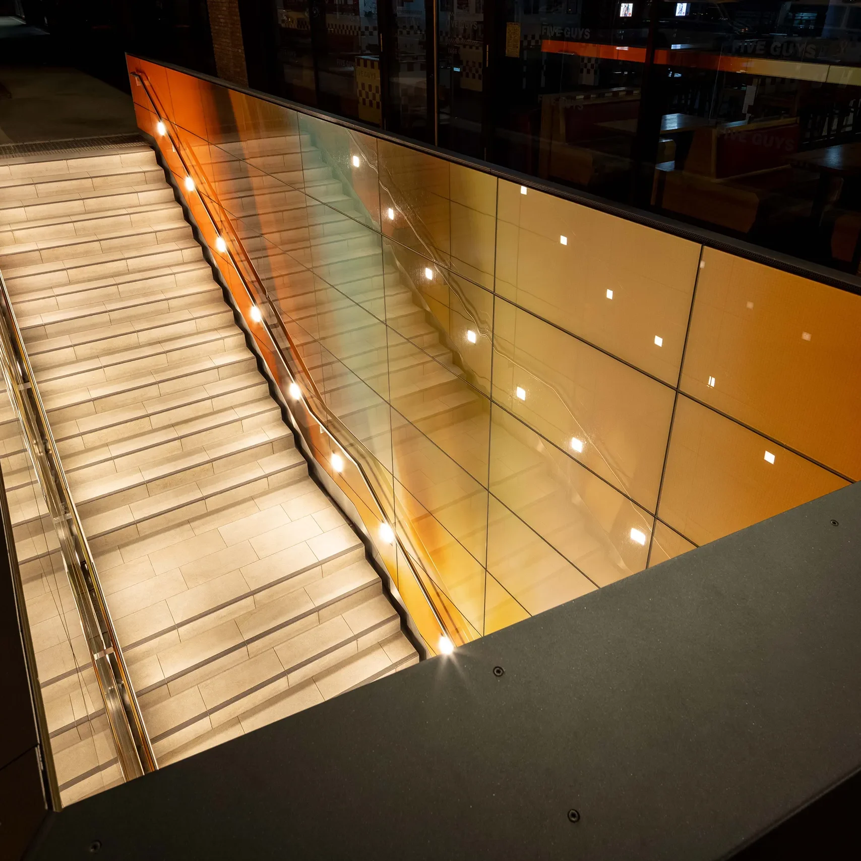 Blick auf den gestalteten Treppenabgang zum U-Bahnhof des Bonner Hauptbahnhofs bei Nacht