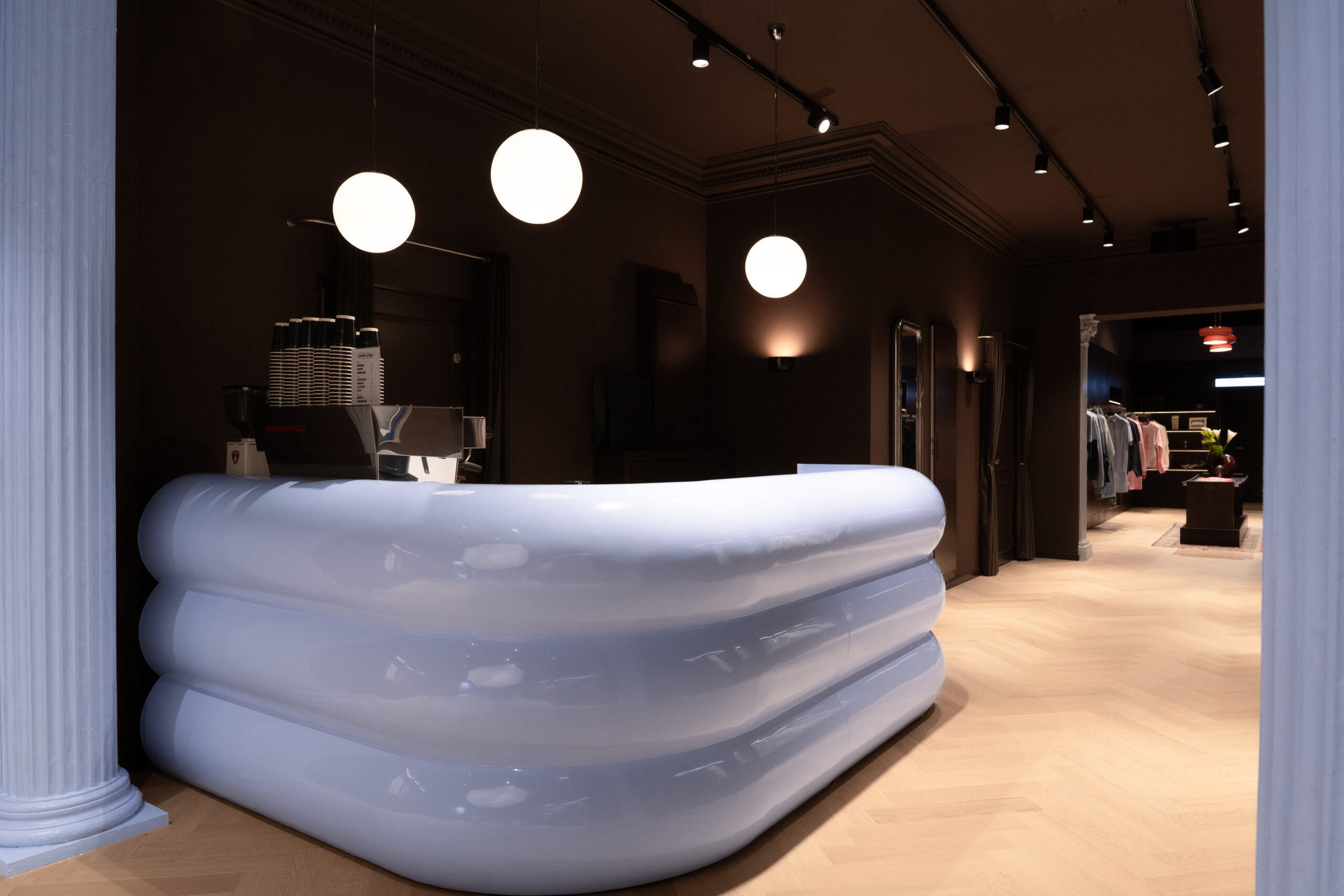 blaue wolkenartige Theke im Another Cotton Lab Store vor dunklem Holz